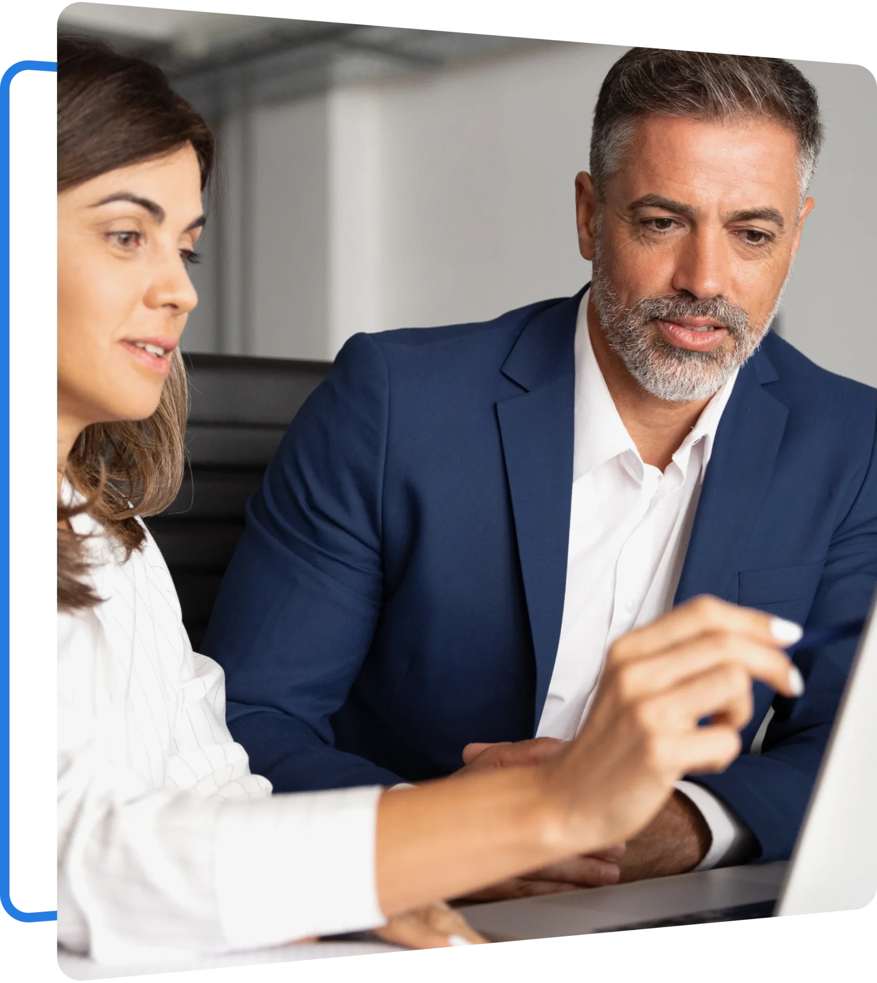Group 5 (1) A man in a blue suit and a woman in a white blouse are sitting at a desk, looking at a laptop screen.
